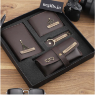 Set of brown leather items with metal accents in a black box, branded